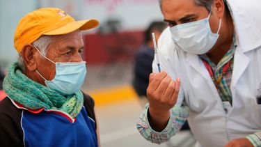 Uno de los enfermeros mexicanos muestra a un anciano una jeringa preparada con una dosis de la vacuna de Sinovac contra el coronavirus antes de aplicársela en el puesto de inoculación instalado en el Centro Cultural y Deportivo Las Américas, en Ecatepec, Estado de México, el sábado 3 de abril de 2021.