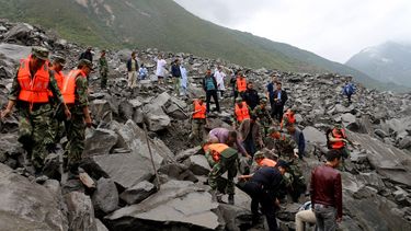 Los equipos de rescate trabajan en el sitio de un derrumbe masivo donde se estima que más de 120 aldeanos están enterrados, en el condado de Maoxian, en la provincia de Sichuan, en el suroeste de China.