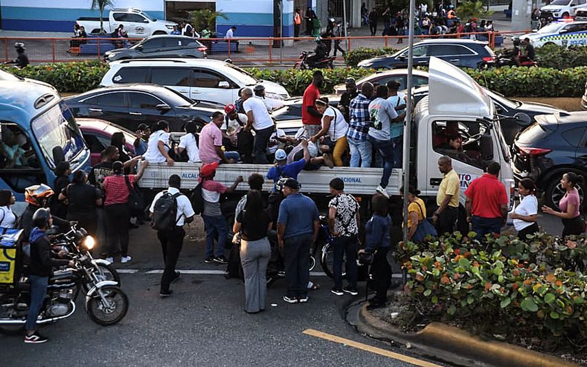 Personas viajan en un camión durante un apagón nacional en Santo Domingo el 11 de noviembre de 2025. Santa Domingo se quedó sin electricidad el martes cuando la compañía eléctrica de la República Dominicana anunció un apagón de alcance no especificado, causado por una falla en el sistema de transmisión.