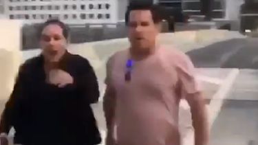 La imagen muestra al hombre armado que camina hacia los ciclistas que discutían con una mujer.