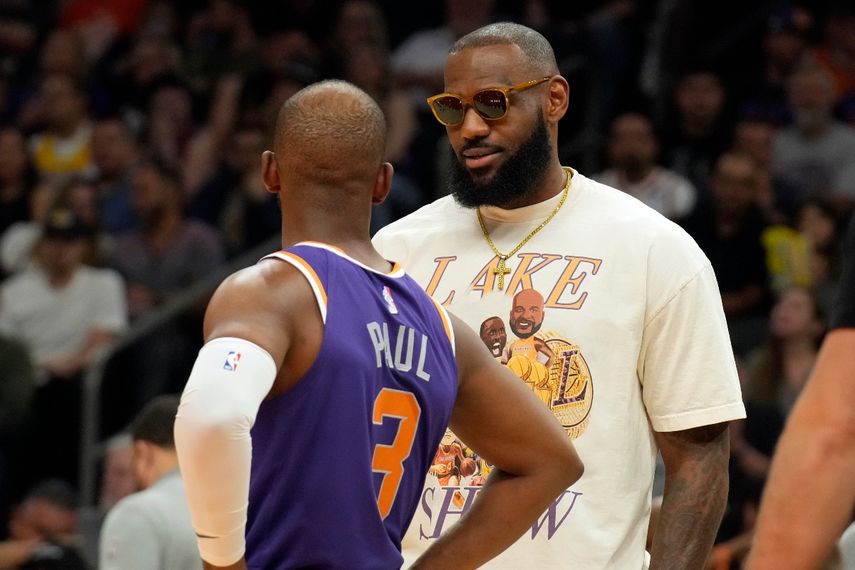 El jugador de los Lakers de Los Ángeles LeBron James habla con el jugador de los Suns de Phoenix Chris Paul (3) en la primera mitad de su juego de NBA el mates 5 de abril de 2022, en Phoenix.
