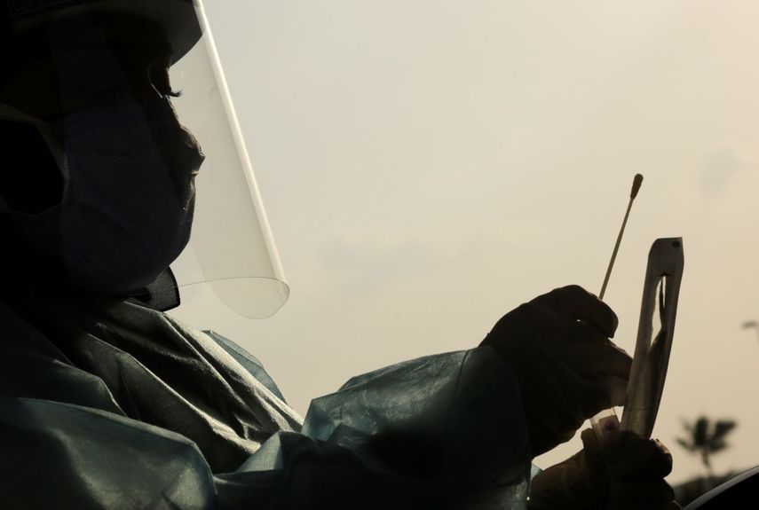 Trabajador de la salud recoge una muestra para un test PCR.