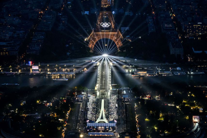 Una fotografía tomada desde un helicóptero el 26 de julio de 2024 muestra una vista aérea de la Torre Eiffel y los anillos olímpicos iluminados durante la ceremonia de apertura de los Juegos Olímpicos París 2024.