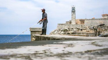 Un hombre pesca desde el muro del Malecón, en La Habana.