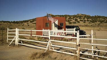Una bandera estadounidense a la entrada del set de filmación de Bonanza Creek Ranch, donde un miembro del equipo recibió un disparo durante la producción de la película occidental Rust, se ve el 28 de octubre de 2021 en Santa Fe, Nuevo México. Armera de filme de Baldwin ignoraba que había balas reales.
