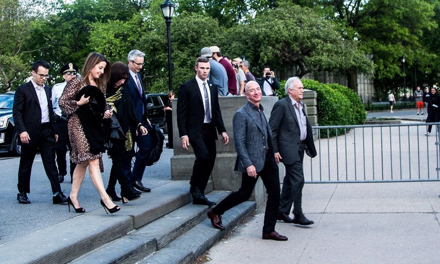 El fundador de Amazon Jeff Bezos (2do der.) llega acompañado de su padres a la inauguración del Museo de la Estatua de la Libertad en Liberty Island, Nueva York.