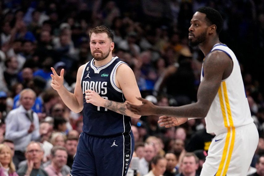 El base de los Mavericks de Dallas, Luka Doncic, celebra un triple frente a JaMychal Green de los Warriors de Golden State en el encuentro del miércoles 22 de marzo del 2023.