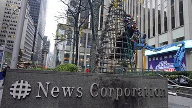 Un trabajador desmonta un árbol de Navidad frente a la sede de Fox News en Nueva York el miércoles 8 de diciembre de 2021. La policía dice que un hombre enfrenta cargos que incluyen incendio provocado por prender fuego al árbol de Navidad de 50 pies en Manhattan.