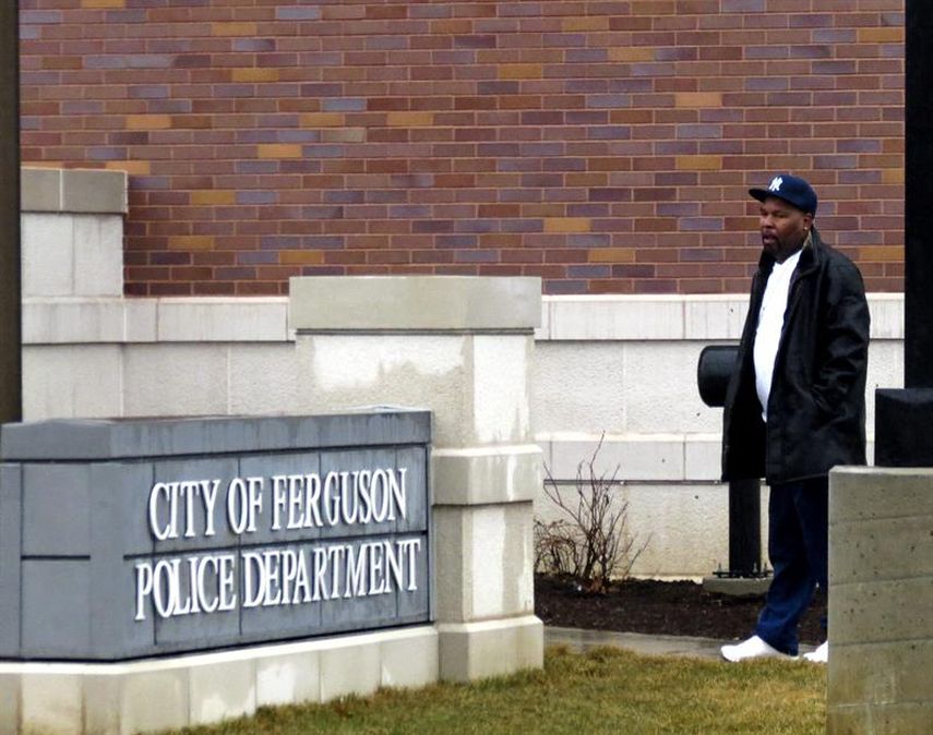 Un hombre camina junto al exterior de la comisaría de policía en Ferguson, Missouri, donde dos policías fueron tiroteados el pasado miércoles. (EFE) 