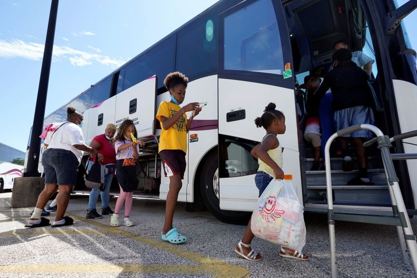 Unas personas que fueron evacuadas de sus hogares abordan unos autobuses en Galveston, Texas, el martes 25 de agosto de 2020.&nbsp;