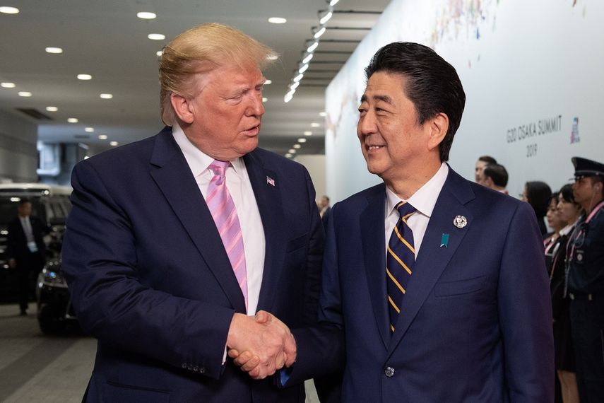 El primer ministro japonés Shinzo Abe (der.) saluda al presidente Donald Trump a su llegada al International Exhibition Center para participar en la Cumbre del G20, en Osaka.