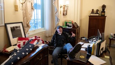 Richard Barnett, sentado en la oficina de la presidenta de la Cámara de Representantes, Nancy Pelosi, mientras protesta dentro del Capitolio de Estados Unidos en Washington, DC, el 6 de enero de 2021.