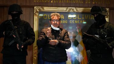 La policía escolta a Maximiliano Dávila mientras éste es presentado ante la prensa en La Paz, Bolivia, el domingo 23 de enero de 2022.