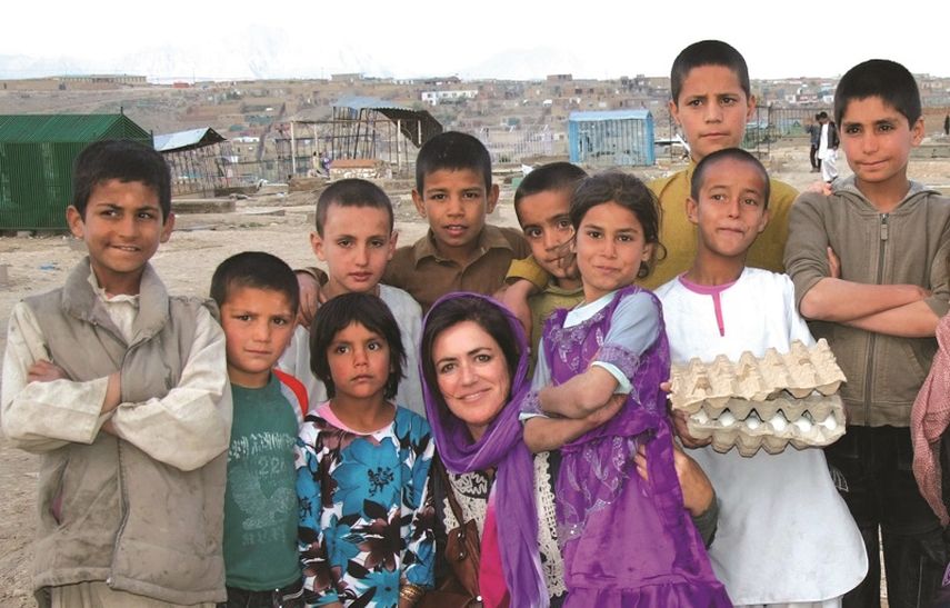 Ana Eulate posa con varios niños durante su visita a Afganistán para repartir el libro El cielo de Afganistán. (CORTESÍA)