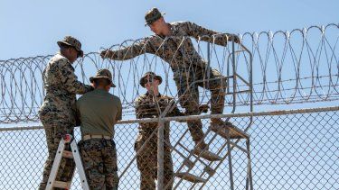 Miembros de la fuerza naval de Estados Unidos trabajan en un alambrado de protección en la Base Naval de Guantánamo.