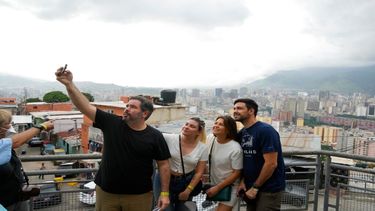 Turistas locales se toman una selfie durante un recorrido organizado por Cumbe Tour en el barrio San Agustín de Caracas, Venezuela.