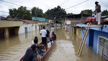 Habitantes navegan por una calle luego de una inundación el pasado sábado. 