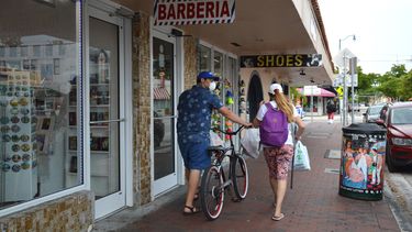 Una pareja camina por una calle de Miami, durante la pandemia de coronavirus.