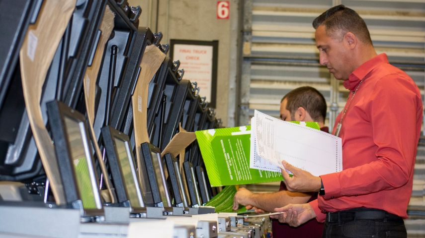 Un trabajador del Departamento de Elecciones de Miami-Dade revisa una de las m&aacute;quinas contadoras de votos.