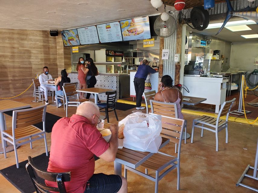 Varios clientes esperan su orden mientras otros consumen en las mesas habilitadas en el restaurante Don Camar&oacute;n en Miami.