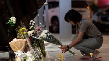 Una mujer enciende una vela en el centro comercial Terminal 21 Korat, en Tailandia, después de una balacera que dejó al menos 29 muertos, el domingo 9 de febrero de 2020.