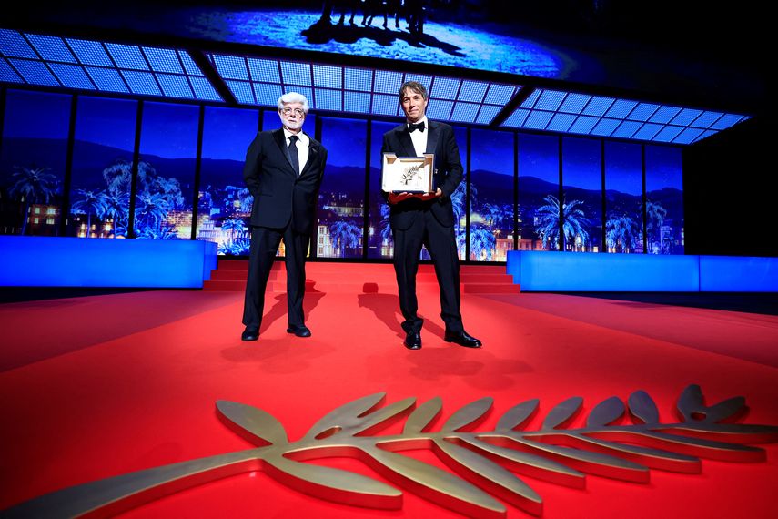 El director estadounidense Sean Baker (derecha) posa junto al director estadounidense George Lucas después de ganar la Palma de Oro por la película Anora durante la ceremonia de clausura de la 77 edición del Festival de Cine de Cannes en Cannes, sur de Francia, el 25 de mayo de 2024.