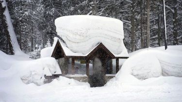 Imagen de archivo. Una persona permanece en una parada de autobús cubierta por la nieve el viernes 24 de febrero de 2023, en Olympic Valley, California. 