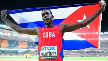 Lázaro Martínez, de Cuba, celebra con su bandera luego de obtener el segundo lugar en su prueba en el Mundial de Budapest.