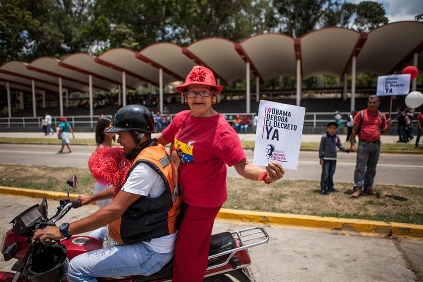 Una mujer sostiene un afiche de protesta contra el decreto del presidente de EEUU, Barack Obama, que considera a Venezuela una inusual y extraordinaria amenaza para la seguridad estadounidense, el martes 31 de marzo de 2015. (EFE)
