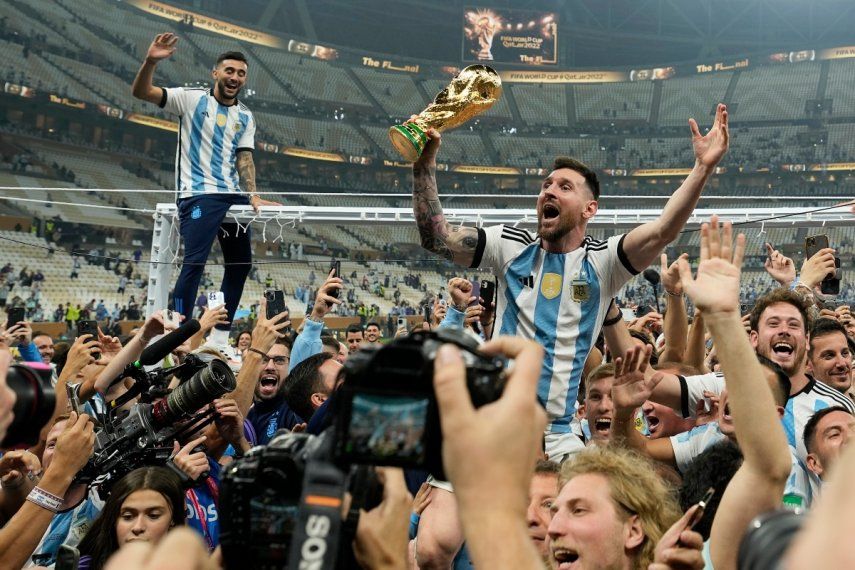 Lionel Messi celebra con el trofeo de campeón mundial con los hinchas de Argentina tras la victoria ante Francia por penales en la final del Mundial, el domingo 18 de diciembre de 2022, en Lusail, Catar.&nbsp;