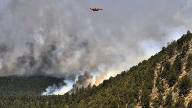 Un avión para combatir incendios vuela sobre un incendio forestal el miércoles 4 de mayo de 2022, cerca de la ciudad de Las Vegas, Nuevo México.&nbsp;