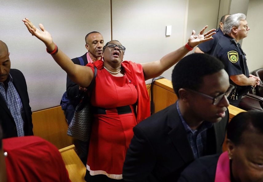 Fotografía del 1 de octubre de 2019 de Allison Jean, la madre de Botham Jean, que extiende los brazos en señal de agradecimiento en la sala de una corte en Dallas, luego de que la expolicía Amber Guyger fuera hallada culpable del homicidio de su hijo.
