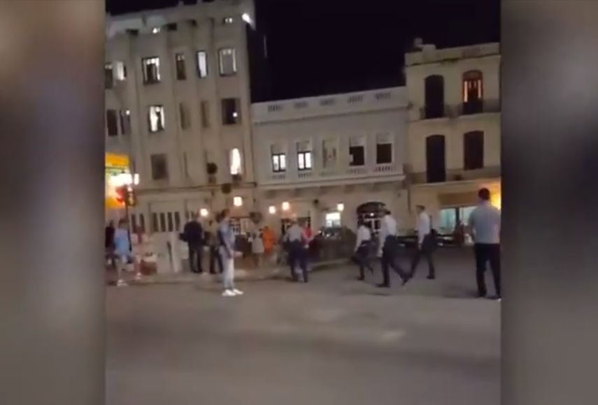 Agentes de la policía política maltratan a un hombre esposado en una plaza pública en La Habana.