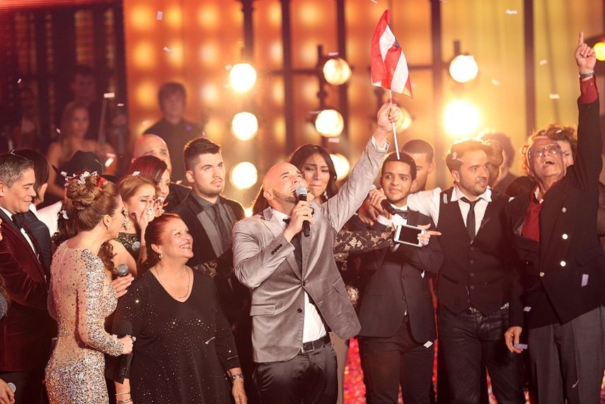 Aarón Emanuel, rodeado de otros concursantes y miembros del jurado, se emociona al saber que es el ganador de Yo soy el artista. (CORTESÍA). 