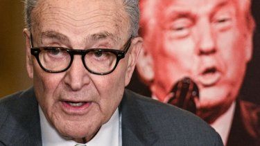 El líder de la minoría del Senado de Estados Unidos Chuck Schumer, demócrata de Nueva York, se encuentra junto a un cartel que muestra una imagen del presidente Donald Trump, mientras habla con la prensa tras una reunión a puerta cerrada con los senadores demócratas en el Capitolio, en Washington, DC, el 3 de marzo de 2026.