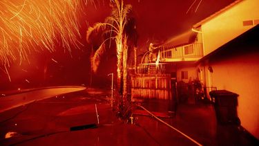 Un bombero echa agua mientras las llamas del incendio Hillside amenazan una vivienda en San Bernardino, California, el jueves 31 de octubre del 2019.&nbsp;