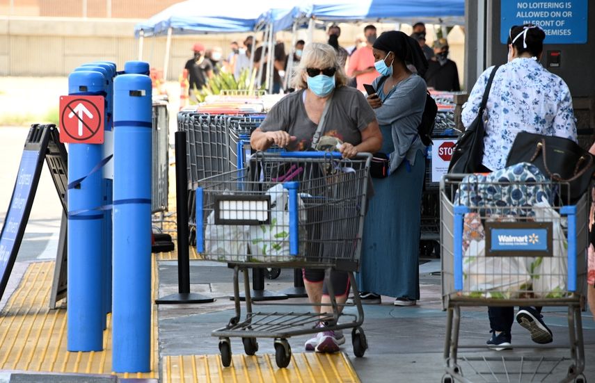 Una mujer que llevaba una m&aacute;scara facial empuja un carrito fuera de Walmart, el 22 de julio de 2020 en Burbank, California.&nbsp;