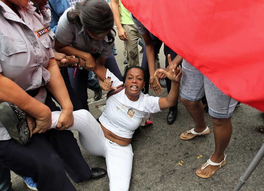Fuerzas policiales cubanas reprimen a una de las integrantes del movimiento disidente Damas de Blanco.