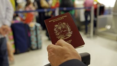 Fotografía de archivo de un hombre que muestra su pasaporte venezolano en el Aeropuerto Internacional de Miami, en junio de 2014.