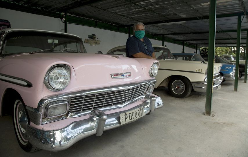 Un hombre posa&nbsp;junto a varios autos antiguos&nbsp;de los usados para transportar turistas por La Habana, Cuba, en tiempos en los que los negocios privados de la isla sufren los efectos económicos negativos que acompañan a la pandemia de COVID-19.