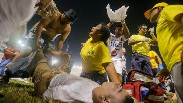 Aficionados al fútbol atienden en la cancha a los heridos por una estampida humana en el estadio Cuscatlán de San Salvador, el sábado 20 de mayo de 2023.