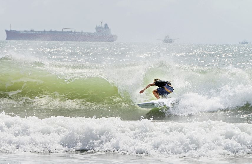 Un surfista se desplaza a orillas de la isla del Padre Sur el viernes 24 de julio de 2020 en medio de un mar picado debido a la tormenta tropical Hanna.&nbsp;