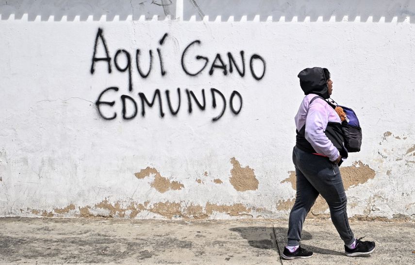 Una mujer pasa frente a un grafiti que dice Aquí ganó Edmundo en Caracas el 28 de octubre de 2024.&nbsp;