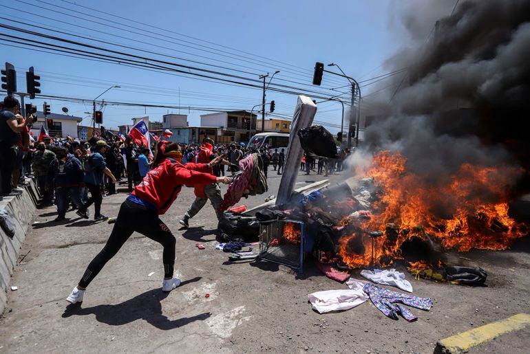 Residentes queman carpas y artículos pertenecientes a migrantes venezolanos y colombianos durante una marcha contra la migración irregular, en Iquique, Chile, el sábado 25 de septiembre de 2021. 