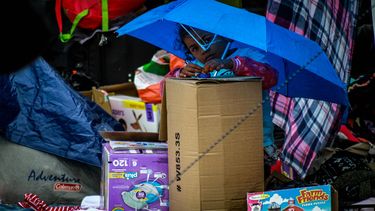Una niña hija de migrantes centroamericanos espera para cruzar con su familia la frontera hacia Estados Unidos en El Chaparra, Tijuana.