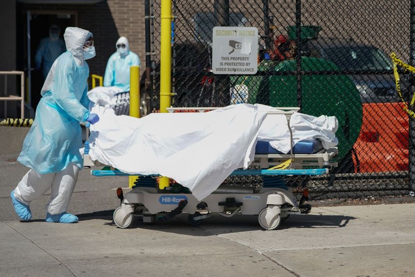 Personal médico traslada los cuerpos a un camión de refrigeración que sirve como depósito temporal de cadáveres en el Hospital Wyckoff en  Brooklyn, Nueva York, el 6 de abril de 2020.