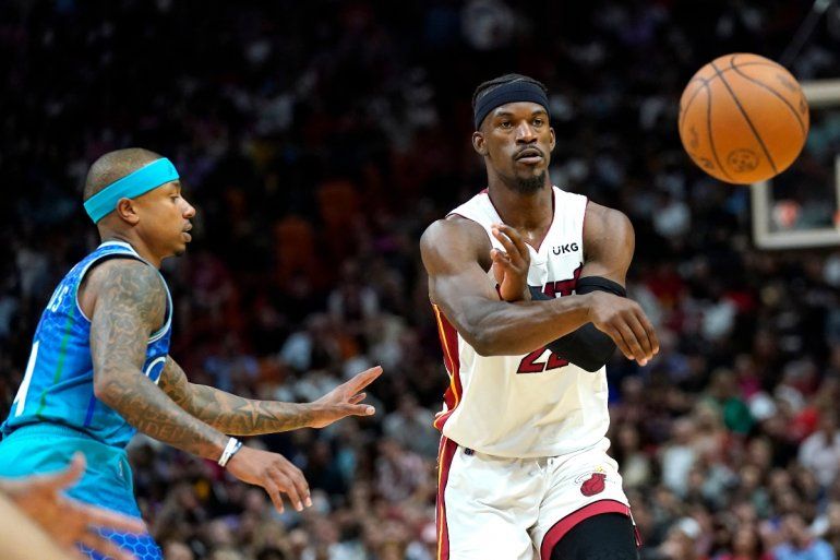 Jimmy Butler, alero del Heat de Miami, envía un pase frente a Isaiah Thomas, de los Hornets de Charlotte, el martes 5 de abril de 2022 