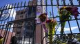 Flores cuelgan de la puerta del cementerio durante el funeral del candidato presidencial asesinado Fernando Villavicencio, el viernes 11 de agosto de 2023, en Quito, Ecuador.