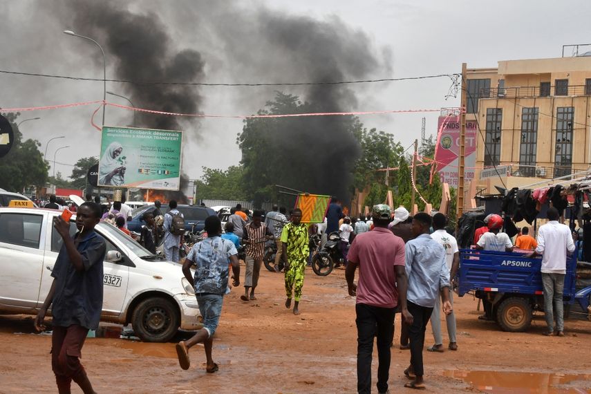 Una vista general de una columna de humo mientras los partidarios de las fuerzas de seguridad y defensa de Níger atacan la sede del Partido para la Democracia y el Socialismo de Níger (PNDS), el partido del derrocado presidente Mohamed Bazoum, en Niamey el 27 de julio de 2023