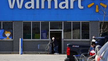 Una persona frente a la entrada de una tienda de la cadena Walmart.